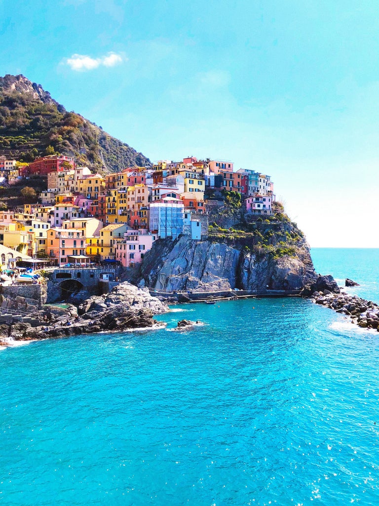 Luxury Italian fishing village with colorful houses and elegant yachts nestled in a hillside harbor along the Mediterranean coast