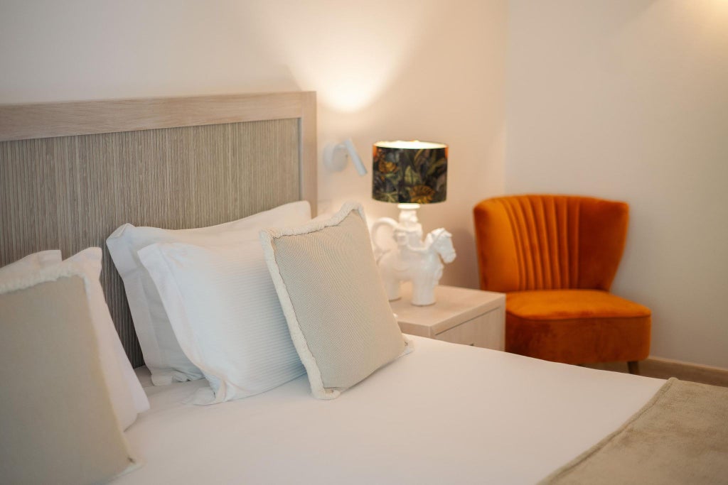 Elegant white-themed hotel room with minimalist design, plush bed, soft neutral tones, and large window overlooking Italian coastal landscape at Canne Bianche Lifestyle Hotel