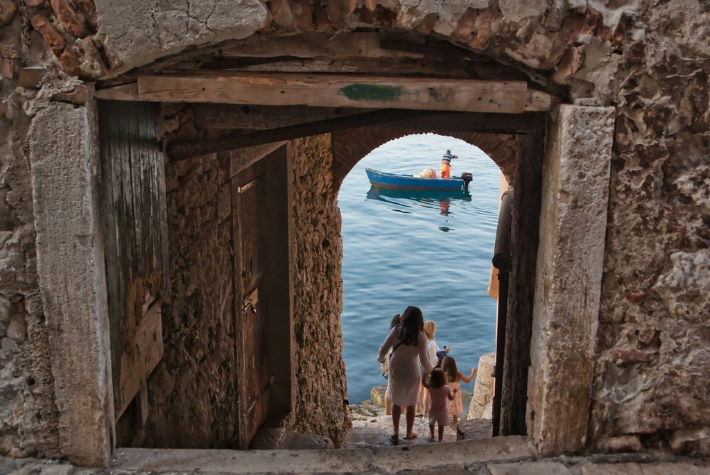 Scenic coastal views of Rovinj's colorful old town houses and St. Euphemia's Church tower rising above Adriatic Sea waters