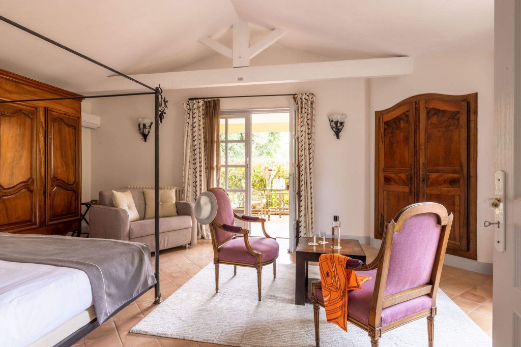 Elegant 18th-century stone hotel room with ornate antique furnishings, soft linens, and warm lighting in a luxurious Provençal monastery setting