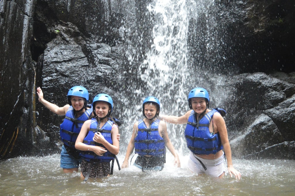 White water rafting adventure on Ayung River, Bali, with professional guides navigating rapids amid lush tropical rainforest scenery