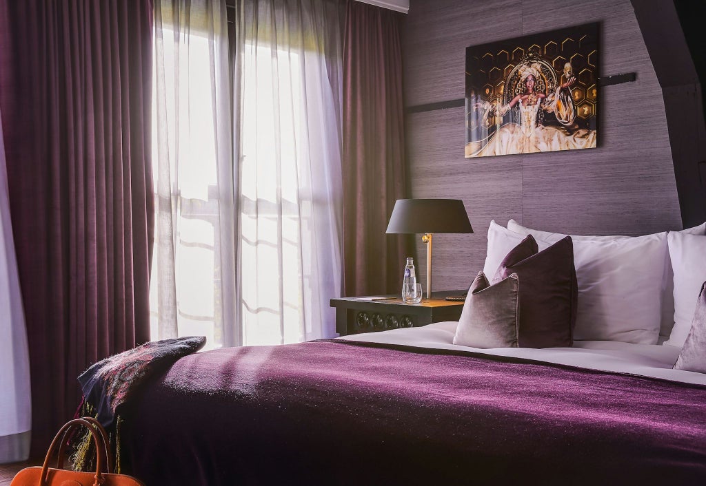 Luxurious canal-side hotel room with large windows, crisp white linens, minimalist decor, and soft natural light overlooking Amsterdam's historic architecture