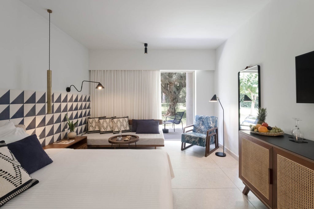 Luxurious Phāea Cretan Malia bungalow with elegant garden view, featuring modern Mediterranean design and plush white bedding