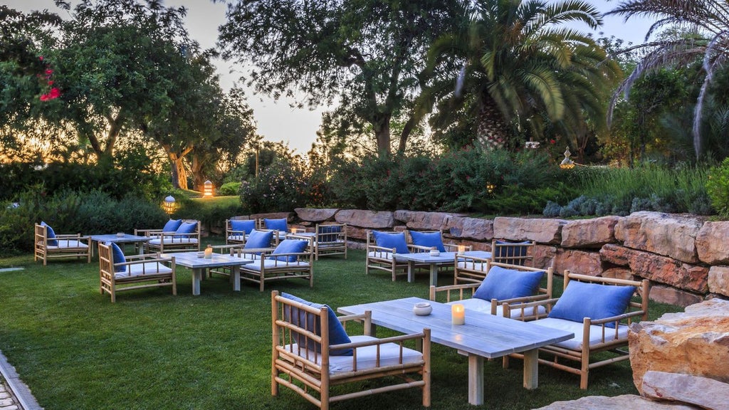 Luxury whitewashed hotel with terracotta roofs nestled in lush gardens, blending traditional Algarvian architecture with modern design in Vila Monte.