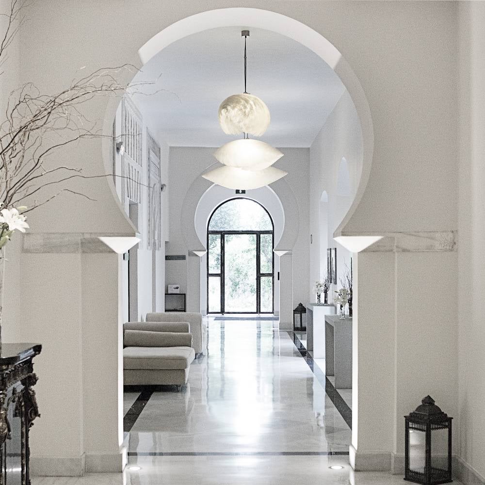 Historic luxury hotel in Córdoba featuring elegant stone archways, marble columns and a serene courtyard with traditional Spanish architecture