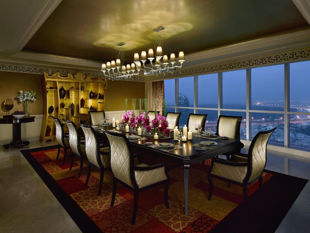 Luxurious Dusit Thani Hotel lobby in Abu Dhabi, featuring elegant marble floors, modern Arabic-inspired decor, and dramatic lighting with crystal chandeliers