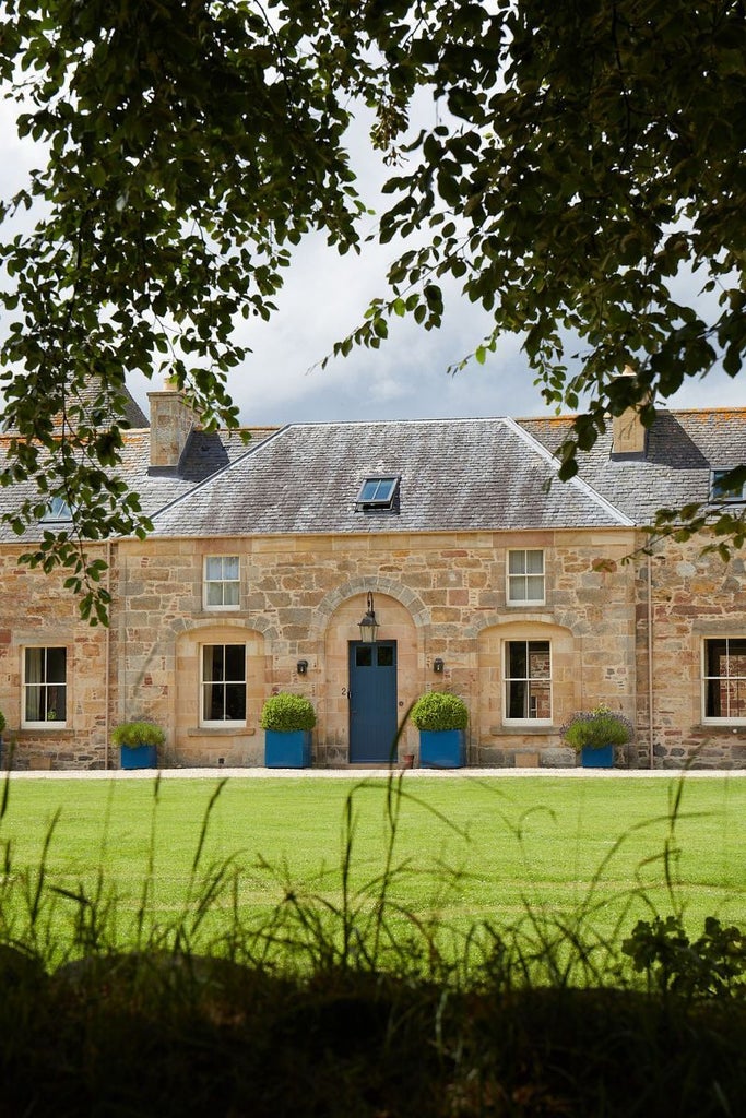 Elegant stone-built Scottish hotel nestled in lush countryside, featuring grand architectural details, manicured gardens, and a serene highland landscape backdrop.