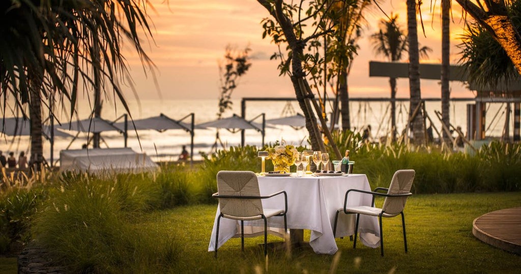 Luxurious beachfront COMO Uma resort in Canggu with infinity pool overlooking ocean waves, modern architecture and swaying palm trees