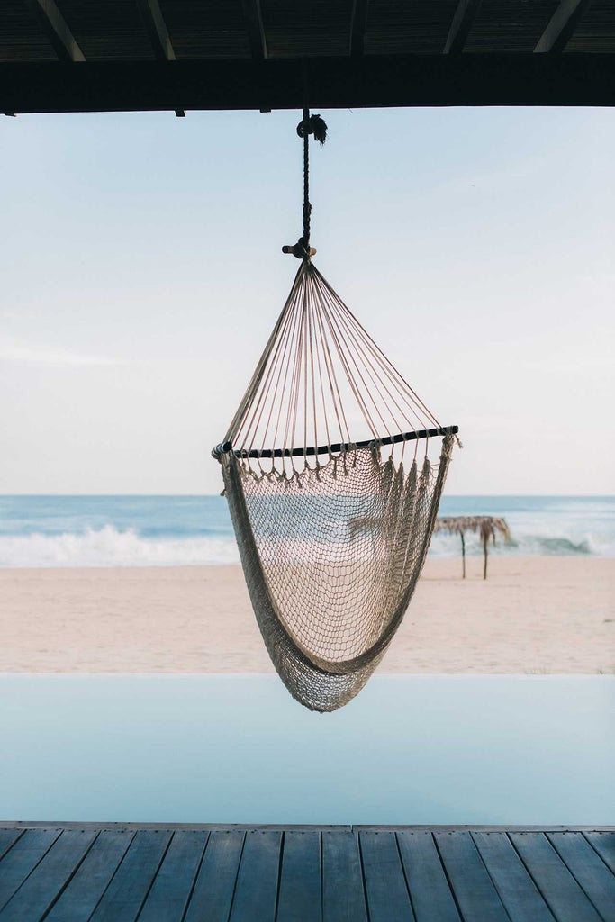 Boutique Hotel Escondido perched on rugged Mexican coastline, with minimalist white architecture, infinity pool overlooking turquoise Pacific waters