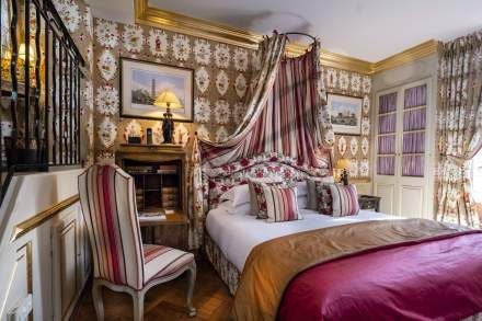 Elegant Deluxe room at Villa Gallici, featuring soft blue color palette, plush white linens, antique French furniture, and ornate decorative accents