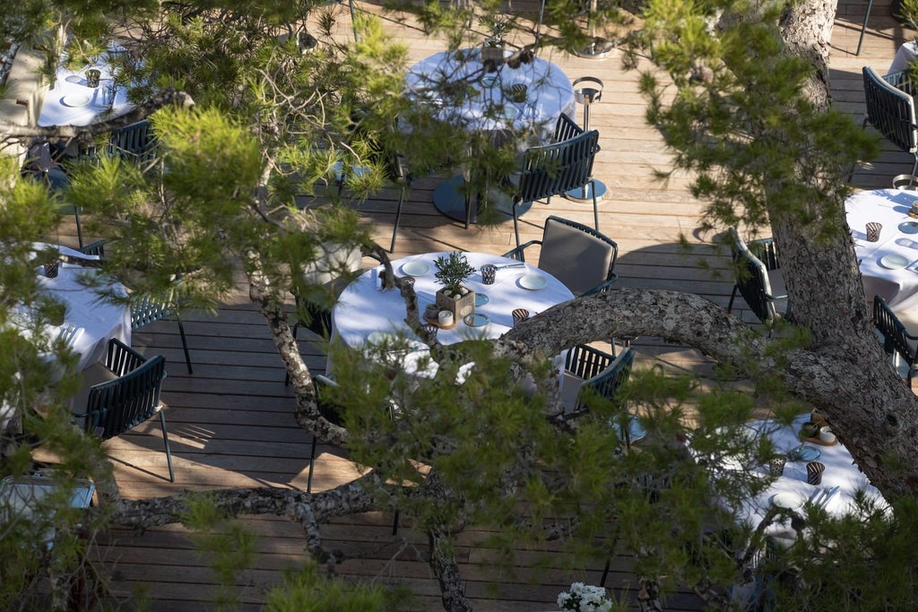 Art Deco luxury hotel with white facade perched on rocky Mediterranean cliffs, featuring panoramic sea views and elegant terraces