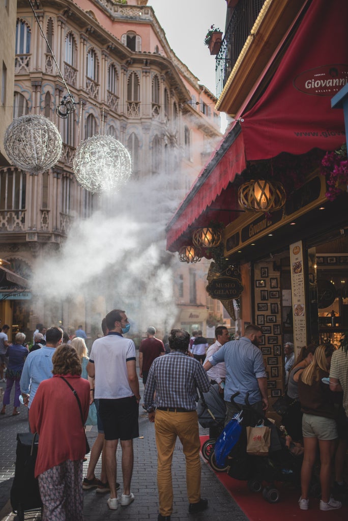 Historic stone streets of Palma de Mallorca with elegant Mediterranean architecture, sunlit alleyways, and luxurious boutique storefronts against backdrop of traditional Spanish urban landscape