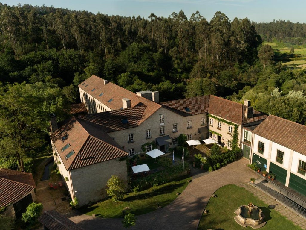 Elegant stone Relais & Châteaux hotel with manicured gardens, classical architecture, and ivy-covered walls in rural Galicia, Spain