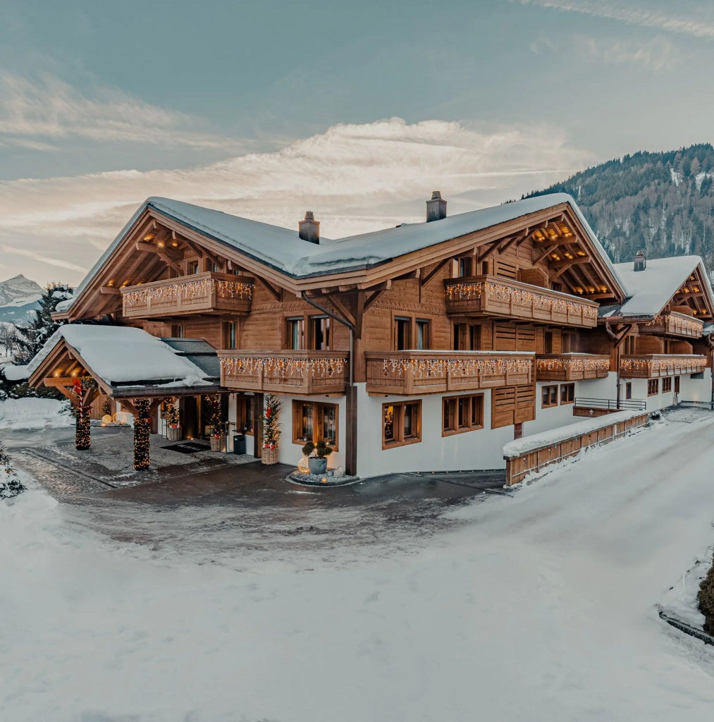 Luxurious alpine ski resort chalet with modern glass walls, snow-capped mountains, sleek contemporary design, and elegant winter landscape surrounding Scenset Hotel in Courchevel