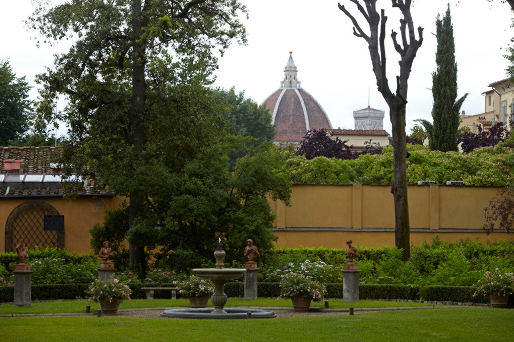 Elegant Renaissance palace exterior of Four Seasons Florence with manicured gardens, ornate stone façade and classic Italian architecture