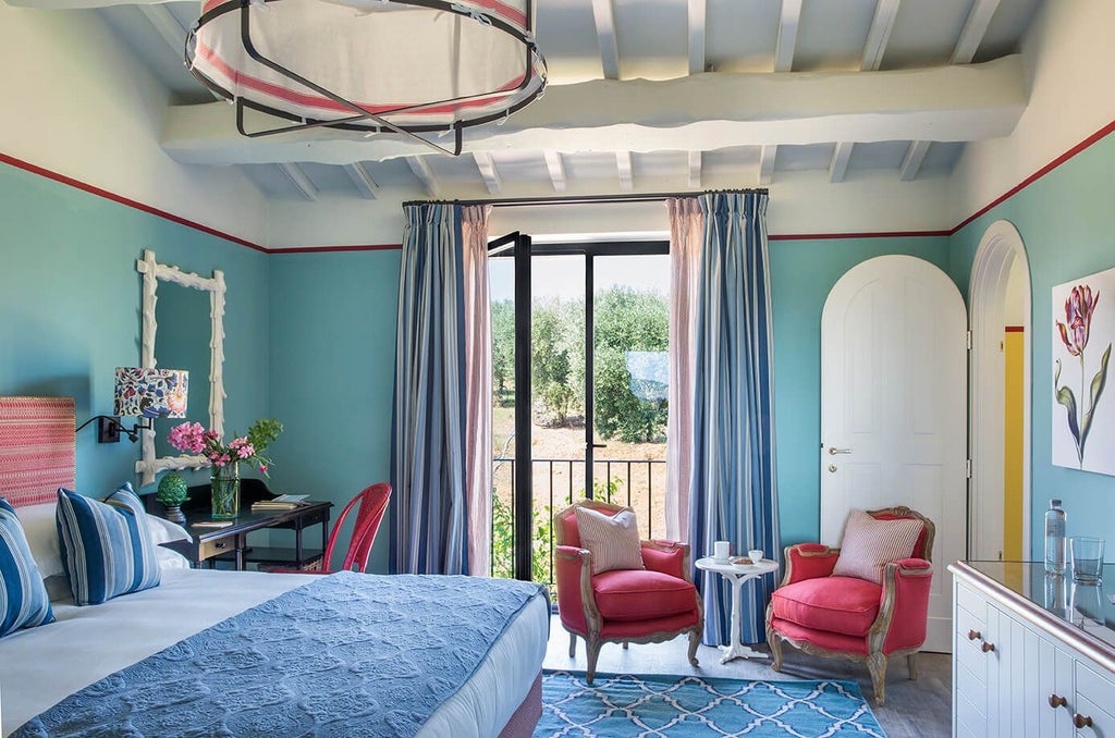 Elegant Tuscan-style deluxe junior suite with king bed, rich terracotta tones, rustic wooden furniture, and panoramic countryside views through large windows