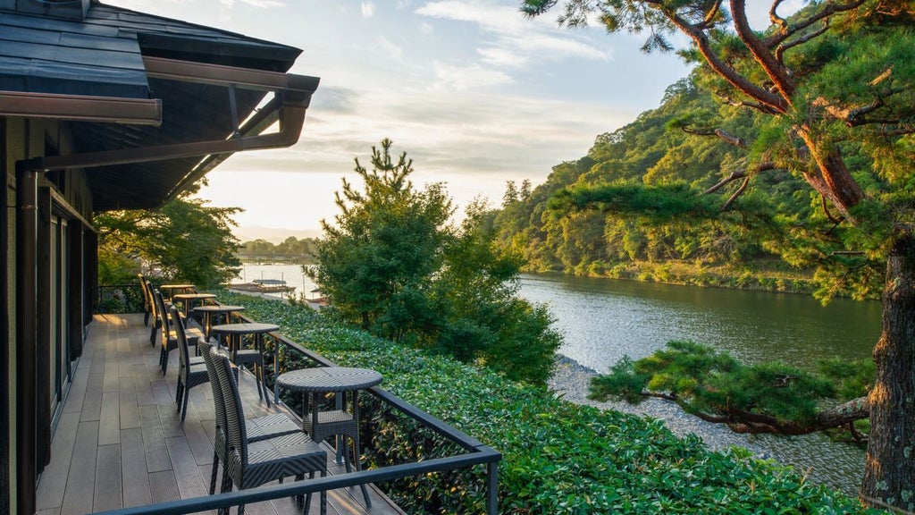 Elegant traditional Japanese ryokan-style luxury hotel nestled by a tranquil Kyoto river, with traditional architecture and lush green gardens at dusk