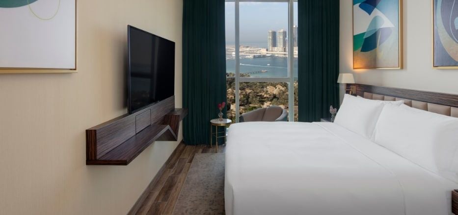 Spacious sea view apartment with modern decor, floor-to-ceiling windows, sleek furnishings, and panoramic Dubai skyline in luxurious Avani+ hotel suite