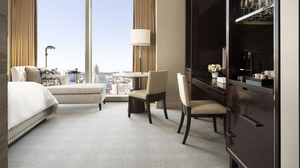 Luxurious accessible hotel room with expansive city views, featuring modern design, plush bedding, and elegant furnishings at a high-end urban hotel in Boston