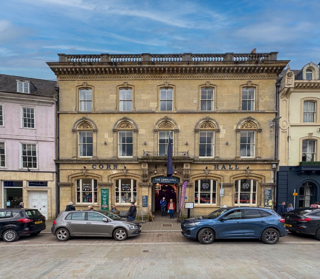 Elegant Victorian-era boutique hotel facade with classic stone architecture and wrought-iron details, nestled in a charming United Kingdom streetscape