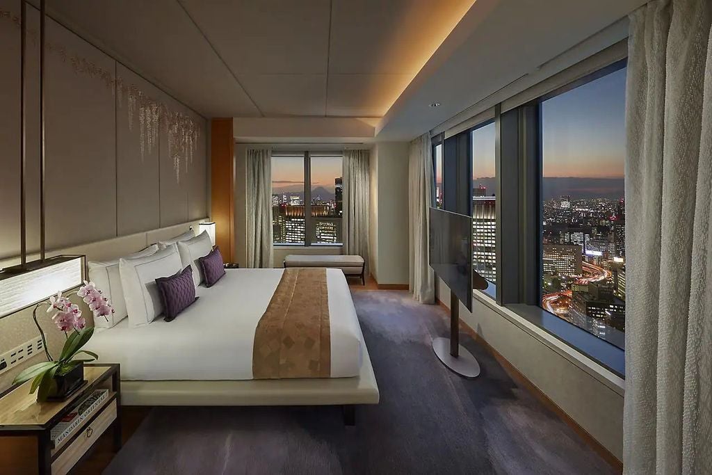 Luxurious Oriental Suite showcasing floor-to-ceiling windows with panoramic Tokyo views, elegant Japanese-inspired decor, and plush seating