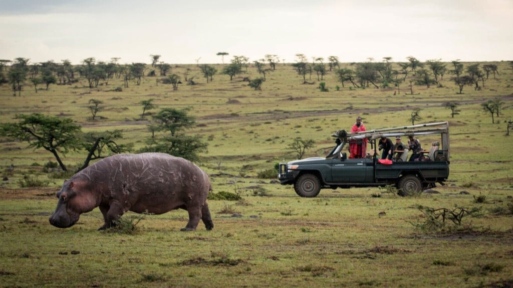 Safari tent with elegant canopy bed overlooking Kenyan savanna at sunrise, featuring rustic-luxe decor and private verandah with wilderness views