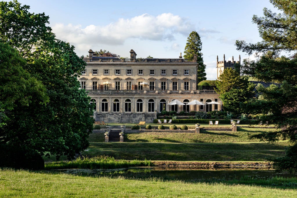 Elegant countryside hotel with contemporary design, featuring modern furniture, large windows, and lush green landscape at a luxurious UK manor retreat