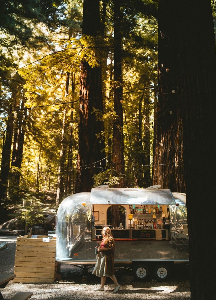 Luxurious safari-style tent nestled in Big Sur forest, featuring private deck, outdoor furniture and panoramic wilderness views