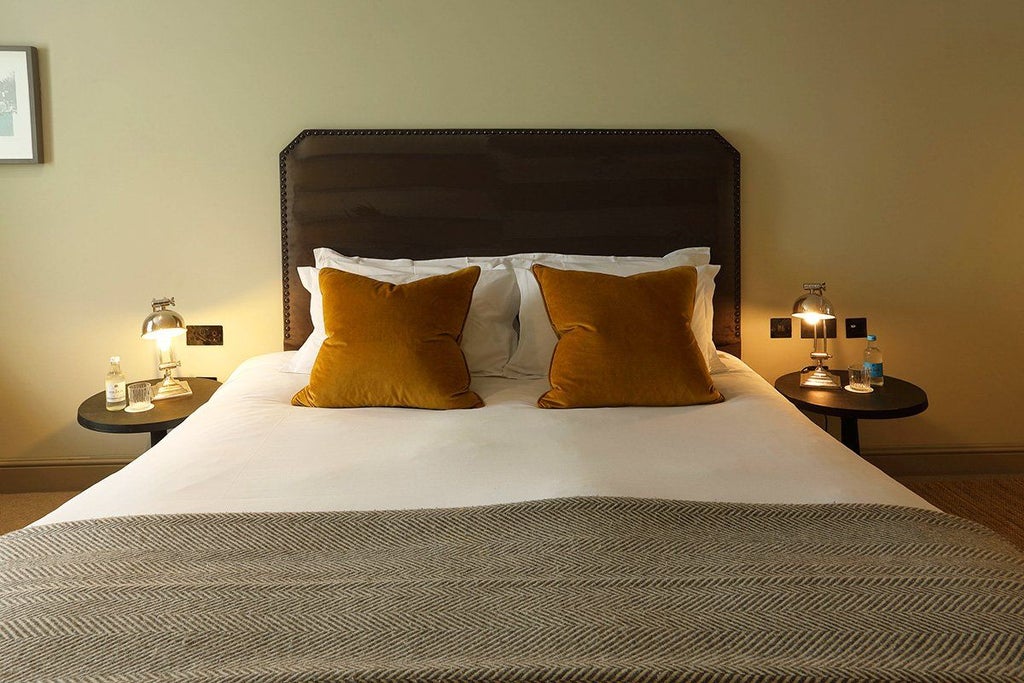 Elegant superior hotel room with plush king-sized bed, tasteful decor, rich wooden furnishings, and soft neutral color palette in a charming United Kingdom setting