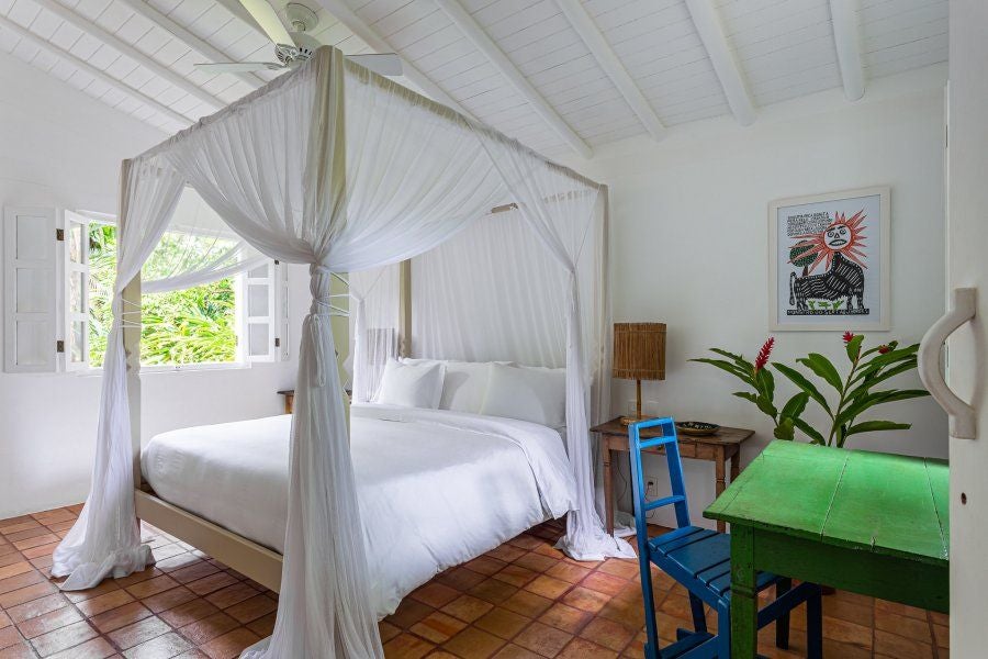 Rustic-chic wooden bedroom at UXUA Casa Hotel in Trancoso, Brazil, with bohemian decor, tropical warmth, and vintage Brazilian design elements