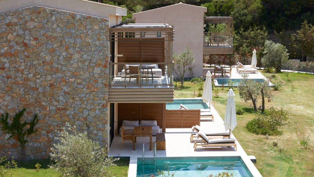 Luxurious junior suite at ELIVI Skiathos with private pool, modern minimalist design, white and blue color palette, overlooking scenic Greek landscape