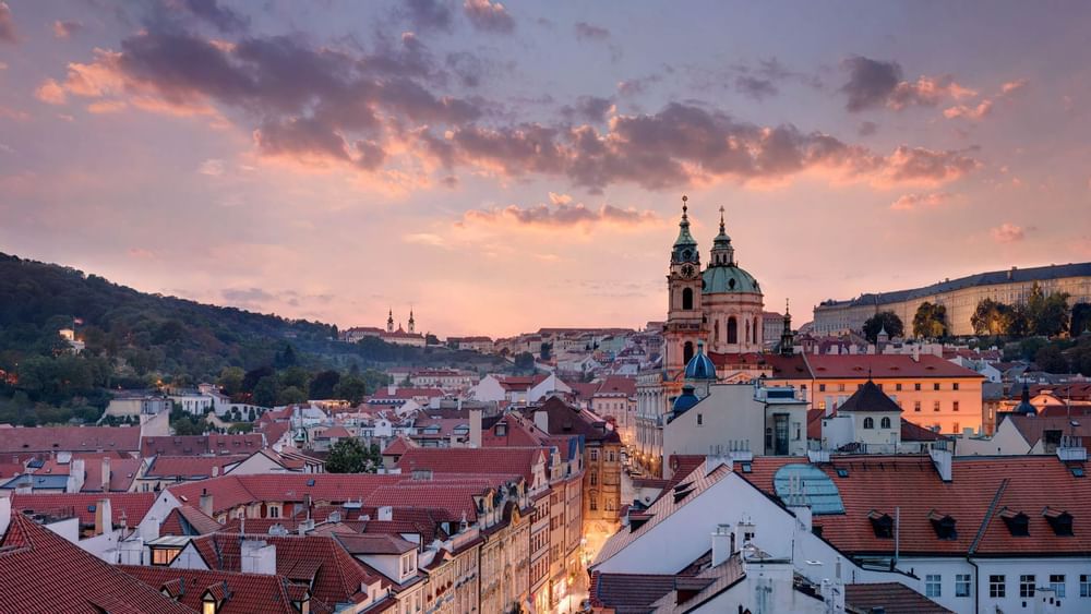 Elegant Art Deco hotel facade with bronze accents, illuminated at dusk, showcasing Prague's historic architectural splendor and luxurious hospitality design