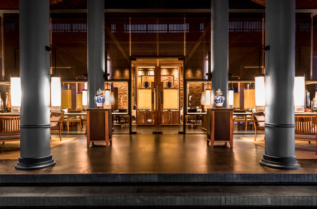 Luxurious open-air pavilion at Amanoi resort perched on cliffside, overlooking turquoise Vinh Hy Bay and lush Vietnamese coastline