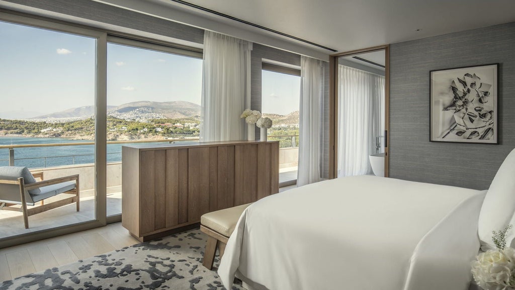 Alt: Elegant presidential suite with panoramic sea views, featuring marble bathrooms, floor-to-ceiling windows, and plush contemporary furnishings