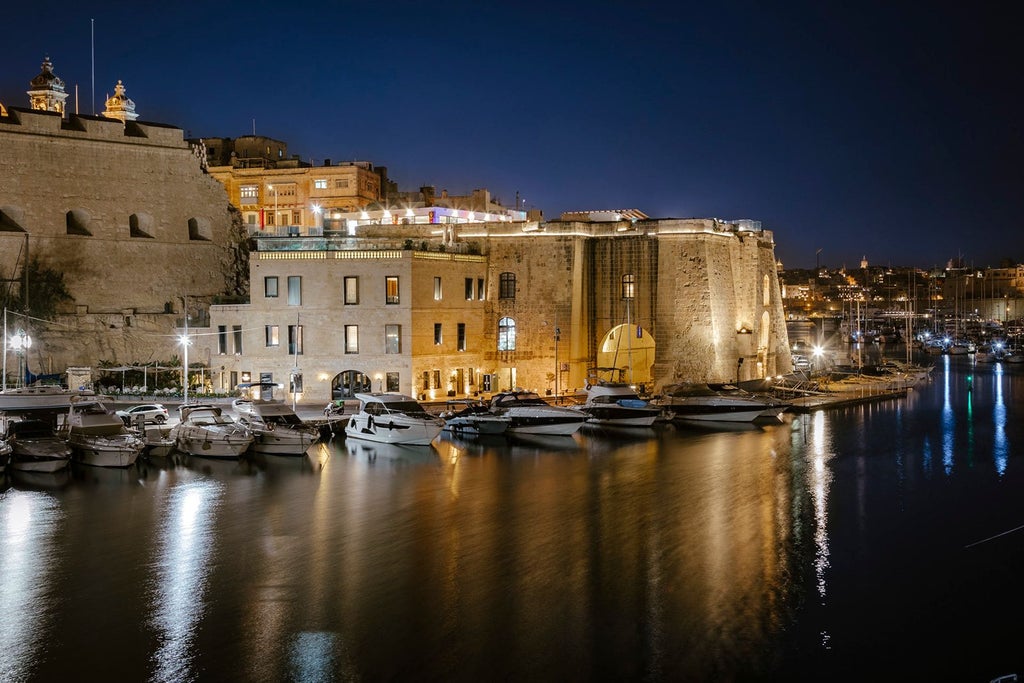 Luxurious historic stone building of Cugó Gran Macina hotel in Senglea, Malta, showcasing elegant architecture with warm Mediterranean lighting