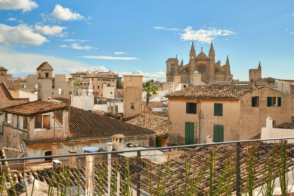 Opulent sky suite in historic Spanish mansion, featuring antique furnishings, plush white bedding, and expansive windows overlooking lush garden terrace