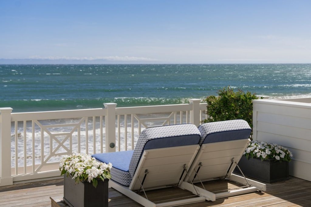 Elegant coastal-style Beach House guestroom at Rosewood Miramar Beach with plush white bedding, ocean-inspired decor, and soft natural lighting