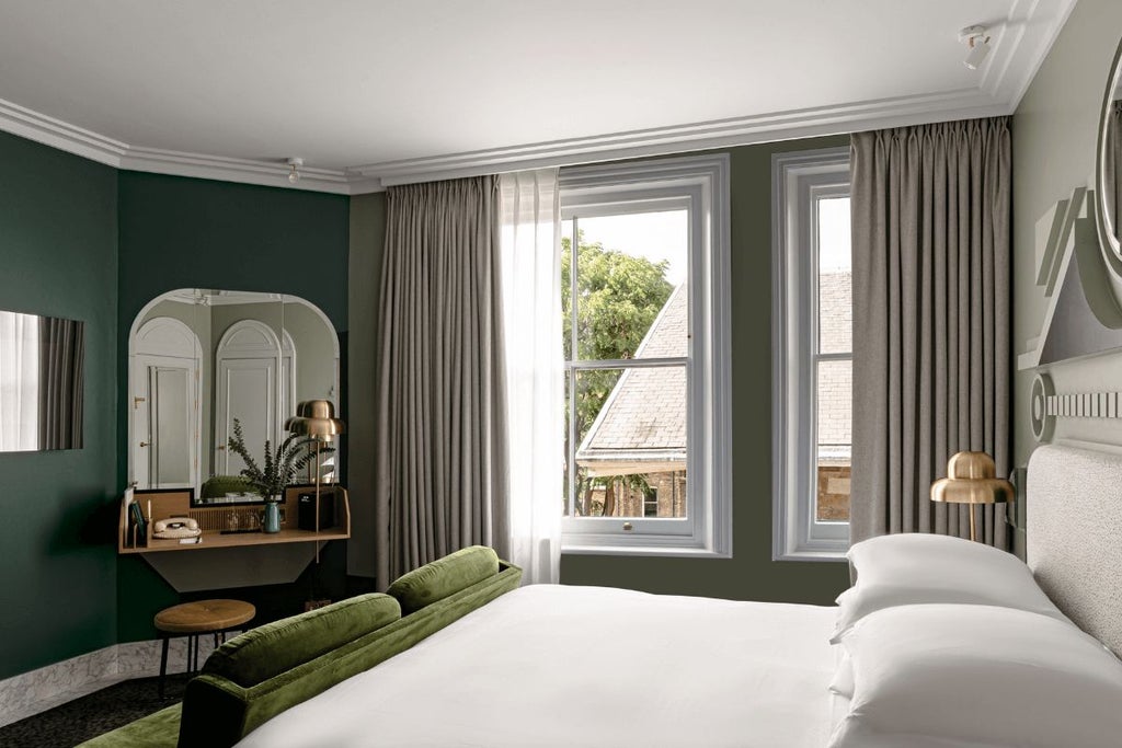 Luxurious boutique hotel room with elegant white decor, plush bed, and chic design details showcasing refined hospitality in a charming UK setting