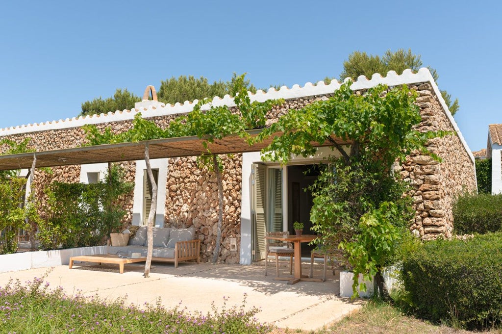 Minimalist white-washed Spanish hotel room with panoramic Mediterranean sea view, clean lines, and elegant coastal design in Menorca's luxurious Torralbenc retreat