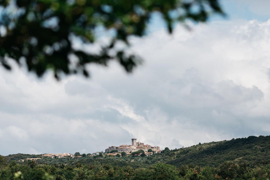 Rustic Tuscan farmhouse-style luxury hotel with stone walls, terracotta roof, cypress trees, and lush green landscape at golden hour