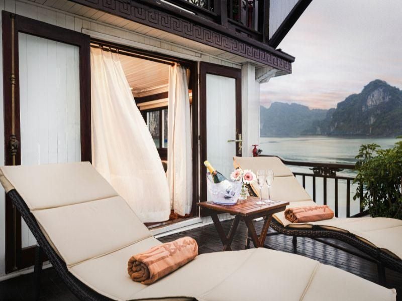 Elegant Terrace Suite with panoramic views of Halong Bay, featuring modern Vietnamese decor, plush king bed, and large windows overlooking turquoise waters