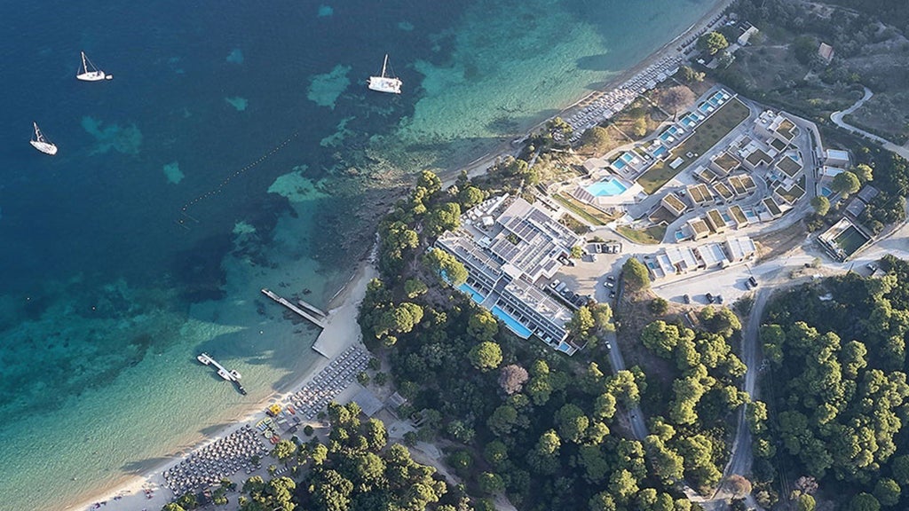 Luxurious beachfront hotel with sleek white architecture, nestled against azure Aegean waters, featuring modern minimalist design and pristine coastal landscape