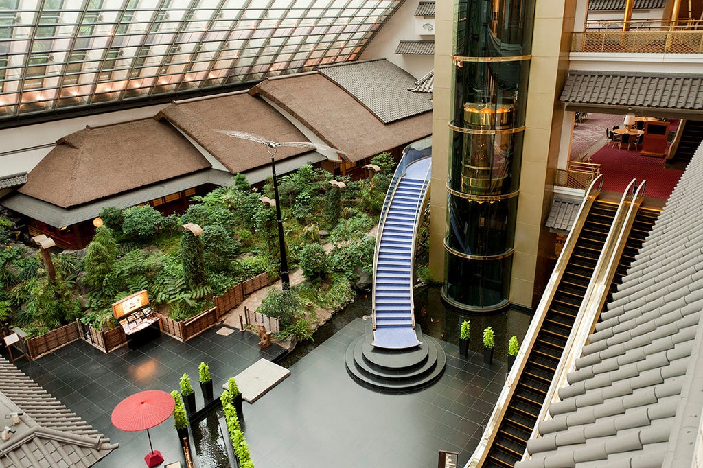 Modern minimalist hotel lobby in Tokyo with sleek marble floors, ambient lighting, and floor-to-ceiling windows overlooking city lights