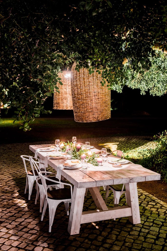 Rustic Portuguese countryside hotel with whitewashed walls, terracotta roof, lush green surroundings, and traditional wooden veranda overlooking rolling hills at sunset