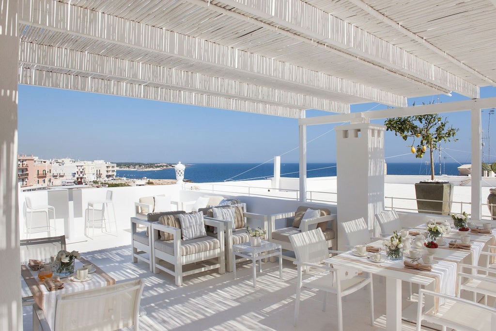 Elegant Mediterranean villa with stone facade, arched windows and balconies overlooking the Amalfi Coast's turquoise waters at sunset