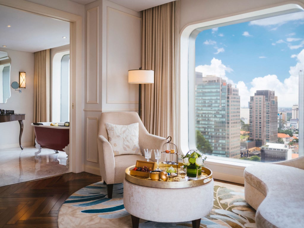 Elegant Art Deco hotel exterior in Ho Chi Minh City features white facade, ornate balconies, and manicured gardens under soft lighting