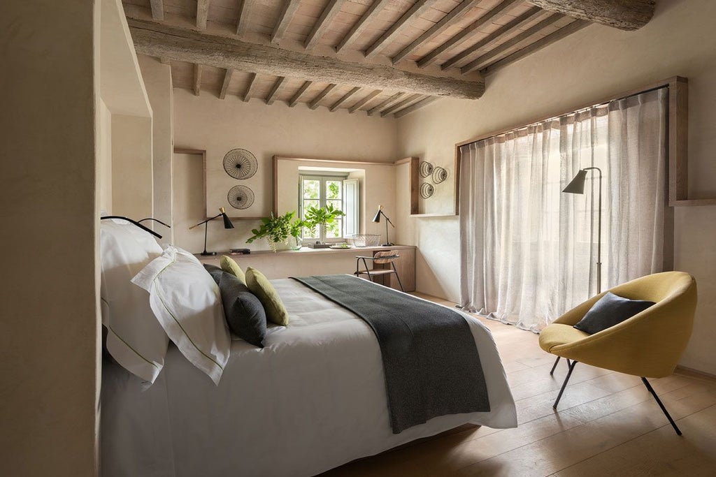 Elegant Italian junior suite with rustic wooden furnishings, plush bedding, and panoramic Tuscan countryside views through large arched windows