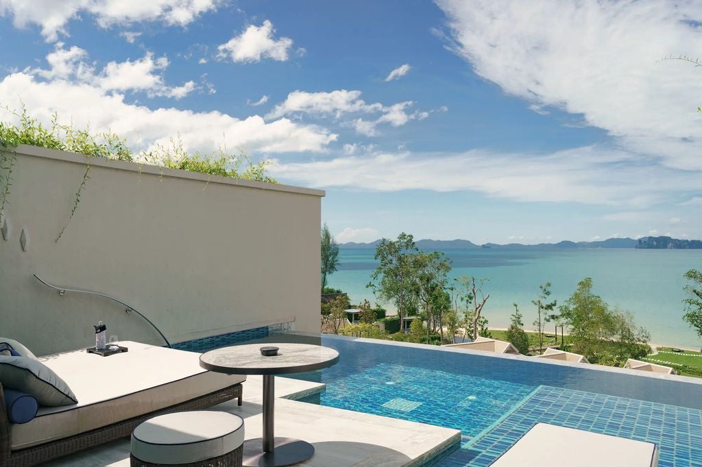 Luxurious king suite with private infinity pool overlooking Andaman Sea, modern Thai decor, floor-to-ceiling windows, and balcony seating