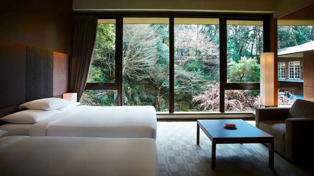 Modern glass-fronted Hyatt Regency hotel in Japan featuring sleek architecture, reflective windows, and elegant stone entrance with water features