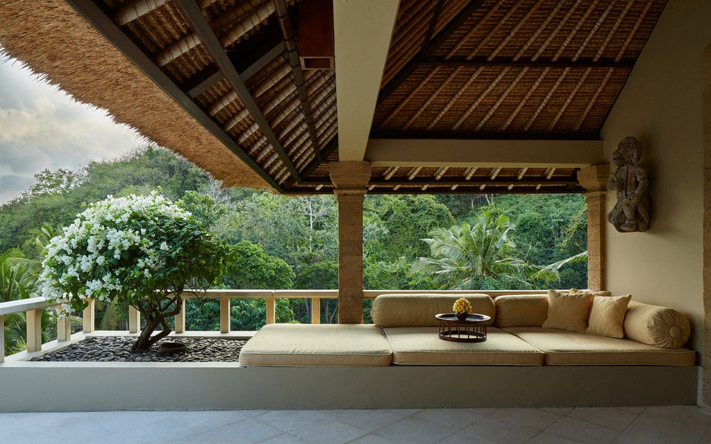 Cascading infinity pools overlooking Bali's eastern coastline, framed by swaying palm trees and traditional thatched pavilions at sunset